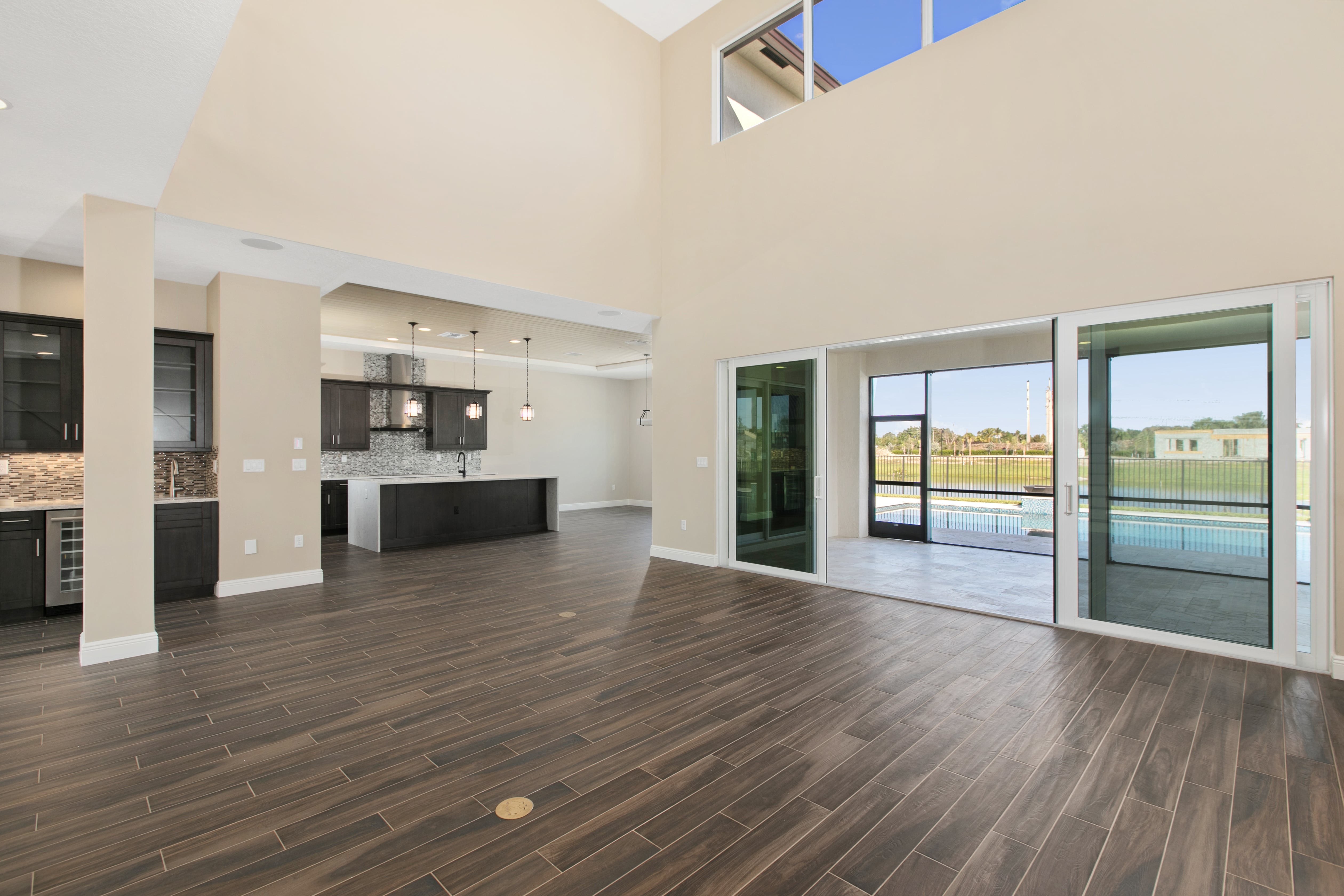 An empty, vacant home with an open layout and large windows. Currently under vacant home management services.