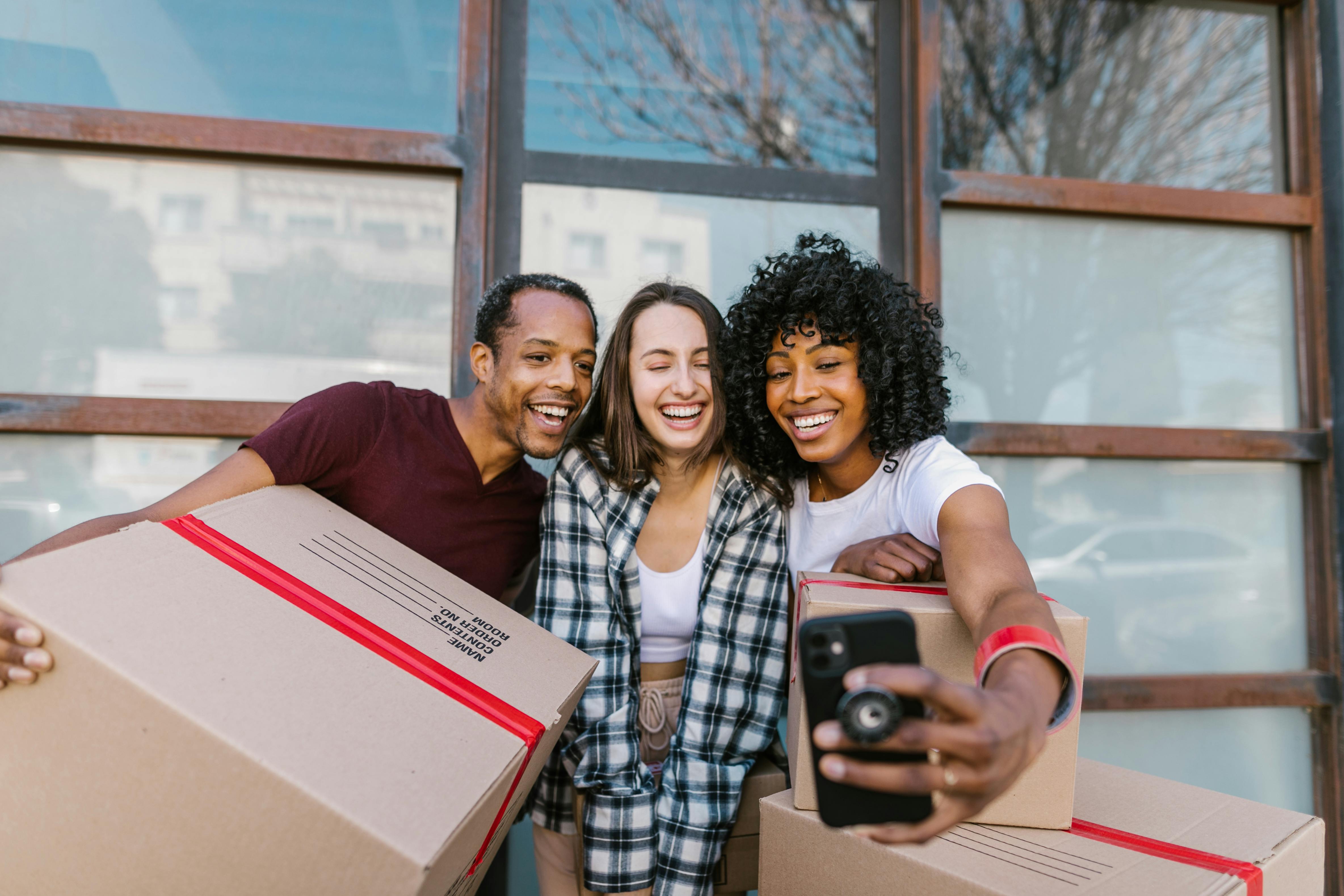 Happy diverse renters taking a move-in selfie