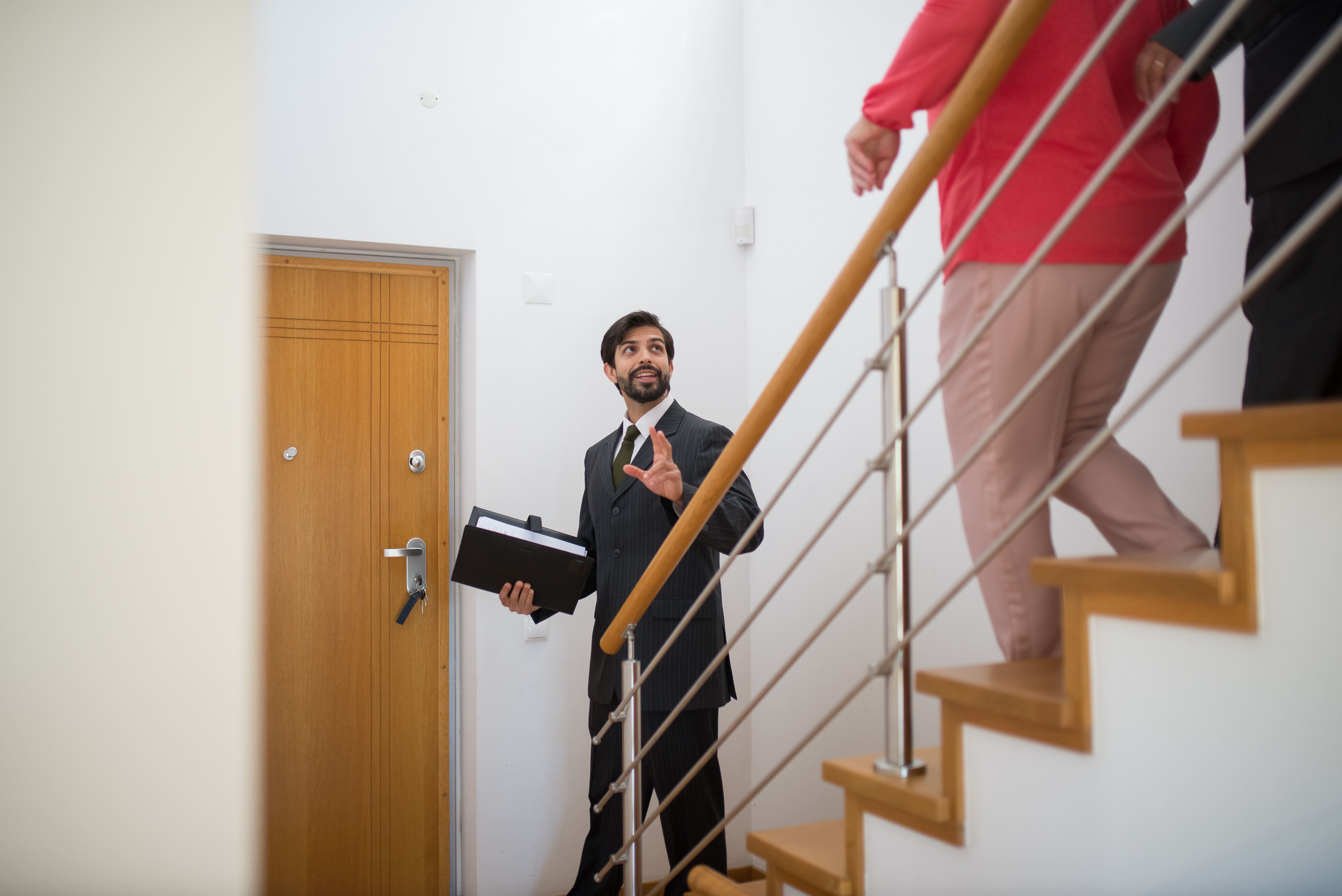 Property manager on a routine inspection walking downstairs with tenants