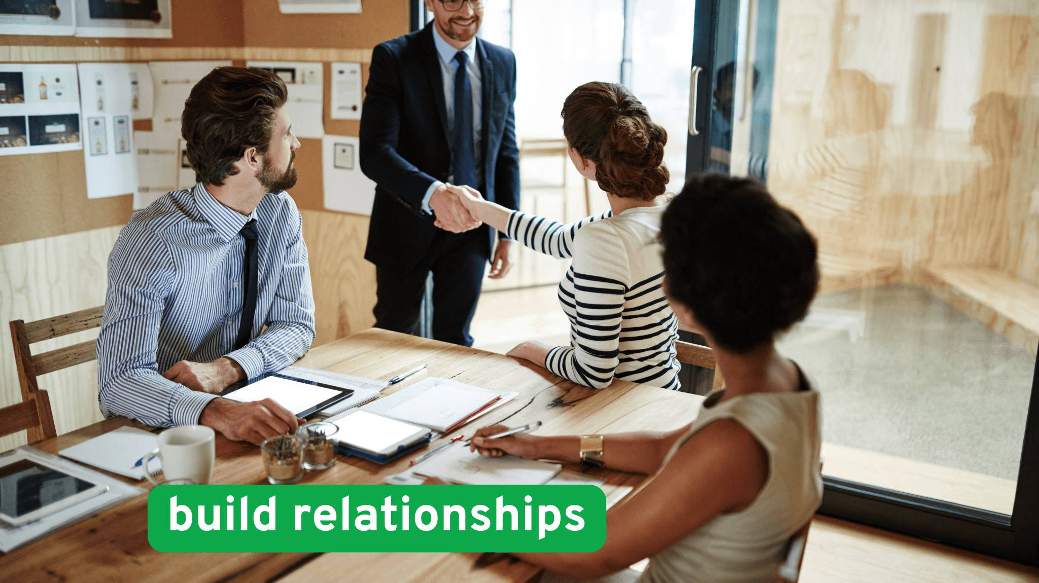 Real estate professionals meeting in a modern office, shaking hands to build professional relationships and grow investment opportunities.