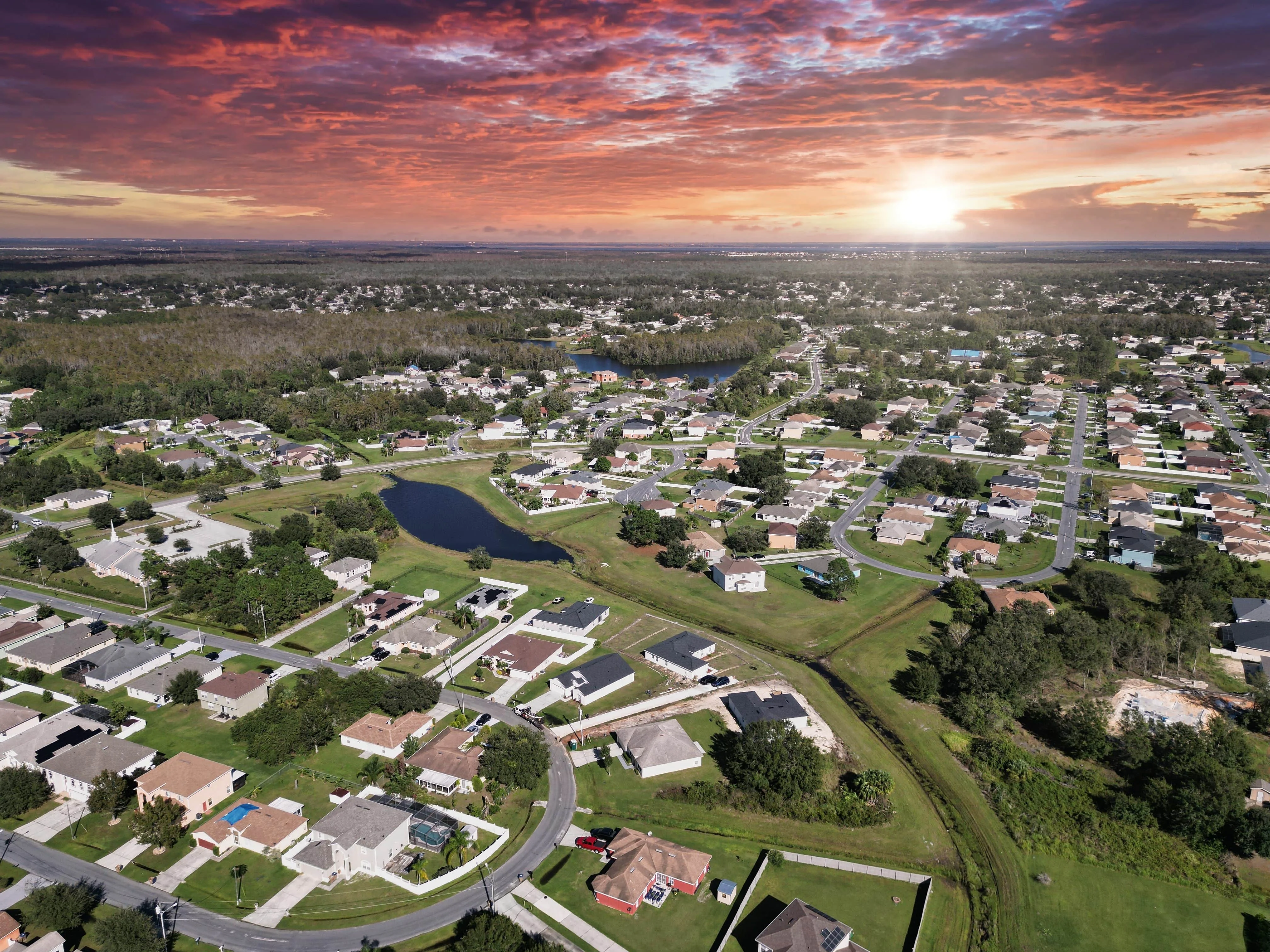 Aerial view of Florida suburban housing community at sunset, representing neighborhood real estate and property investment potential.